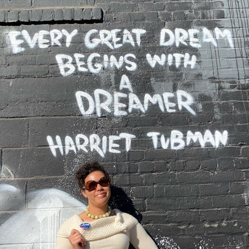 Image of Jessica Wilson in front of a wall with a Harriet Tubman quote, "every great dream begins wi...