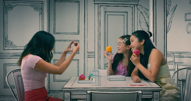 Lara Jean and her sisters pose for a picture at a 2D cafe in Korea in 'To All the Boys: Always and F...