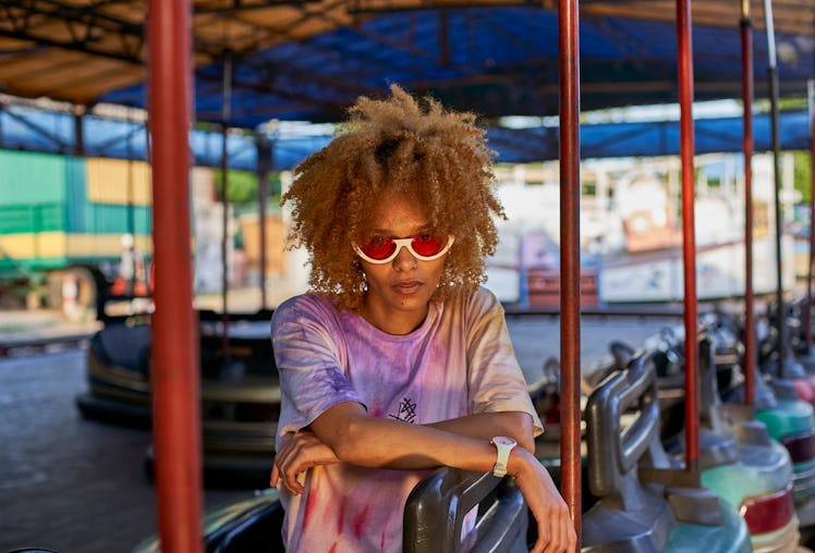 Young woman on bumper car at fair in March