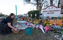A woman places painted rocks at a memorial to those killed in the 2018 Parkland, Florida, school sho...