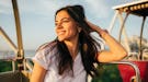 Young woman with her hair blowing in the wind during the fall before posting hair captions, hair cap...