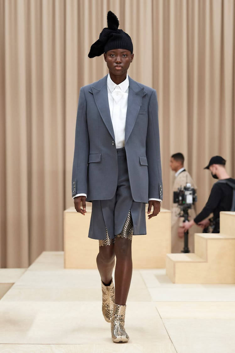 A model in a Burberry grey blazer, shorts, and white shirt at the London Fashion Week