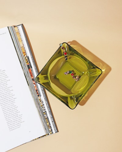A green glass dish for holding jewelry or small tchotchkes.  