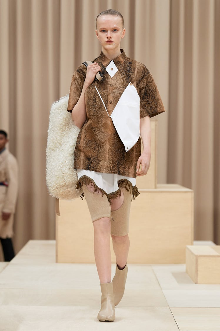 A model in a Burberry brown-white dress, beige shorts and white fur bag at the London Fashion Week