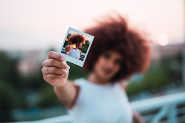 Young woman showing selfie, instant photo of herself, close-up