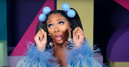 Megan Thee Stallion wears a blue fuzzy top, matching knocker beads that hold two pigtails, and blue ...
