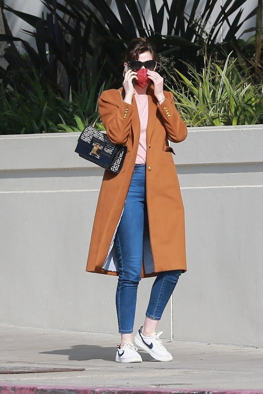 Anne Hathaway stops and switches shoes before going to a meeting in Santa Monica with husband Adam S...