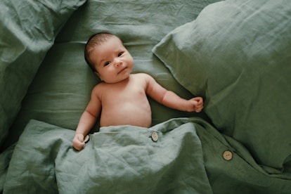 baby lying on green sheets
