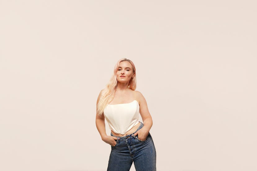 Grace Chatto of Clean Bandit in denim jeans and a white satin corset