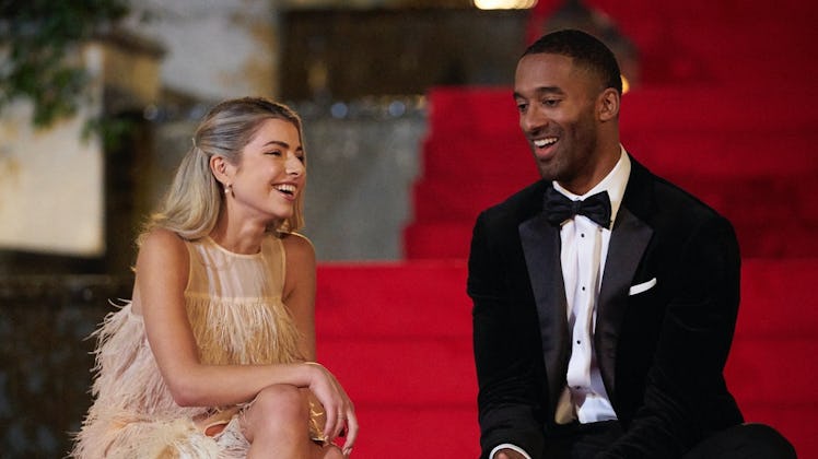 Kit and Matt James laugh while sitting on red carpet steps on 'The Bachelor.'