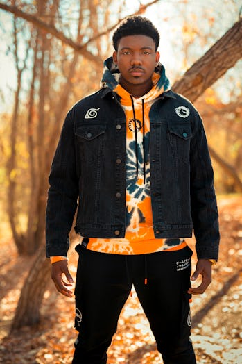 Vader wearing an orange hoodie and black denim jacket with Naruto and TL branding