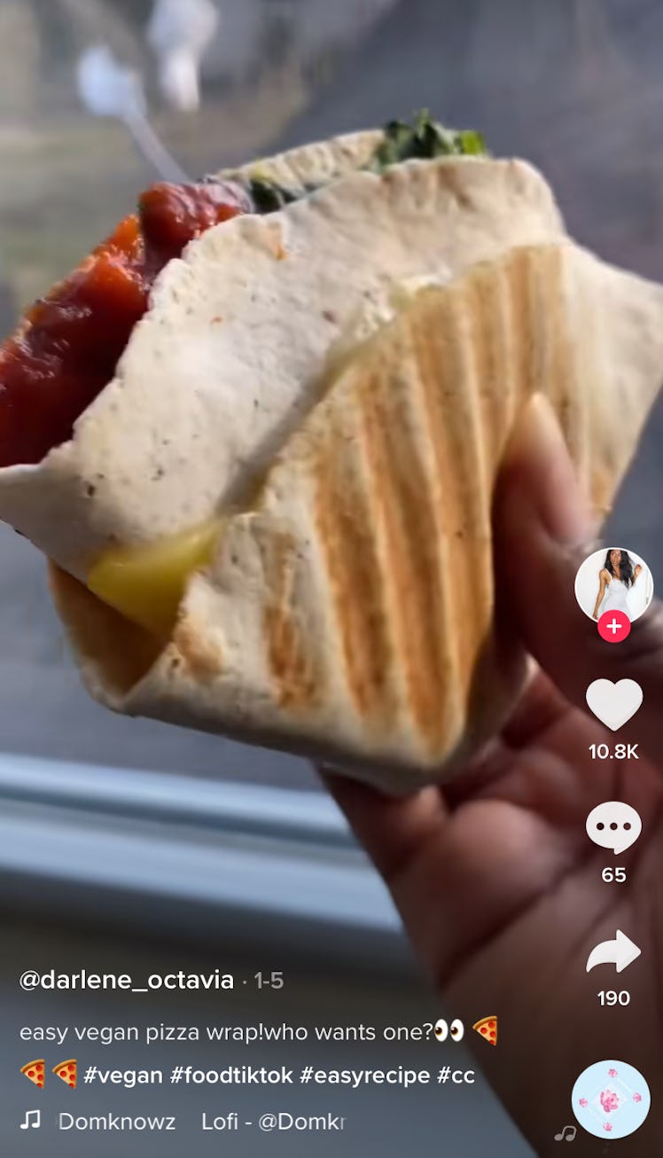 A woman holds up a vegan pizza wrap from TikTok. 