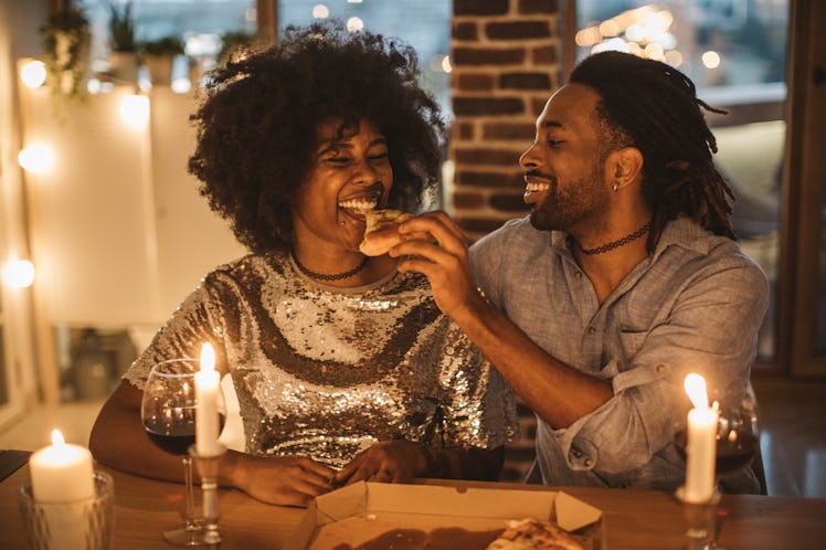 Couple eating pizza on date night at home