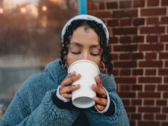 Young woman drinking hot chocolate bomb ahead of Valentine's Day