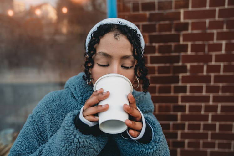 Young woman drinking hot chocolate bomb ahead of Valentine's Day