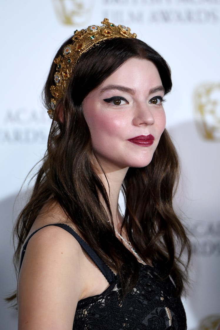 Taylor-Joy at the British Academy Film Awards accessorized with a crown a bold eyeliner and deep lip