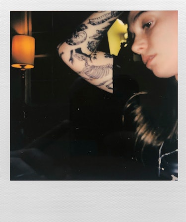 Polaroid of Julien Baker showing off her tattoos on her right arm
