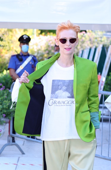 Tilda Swinton wearing sunglasses, a Caravaggio white T-shirt under a green blazer