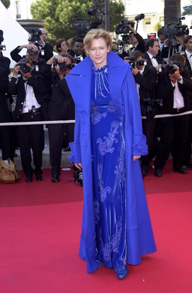 Tilda Swinton wearing a blue dress with white details, and a long blue coat