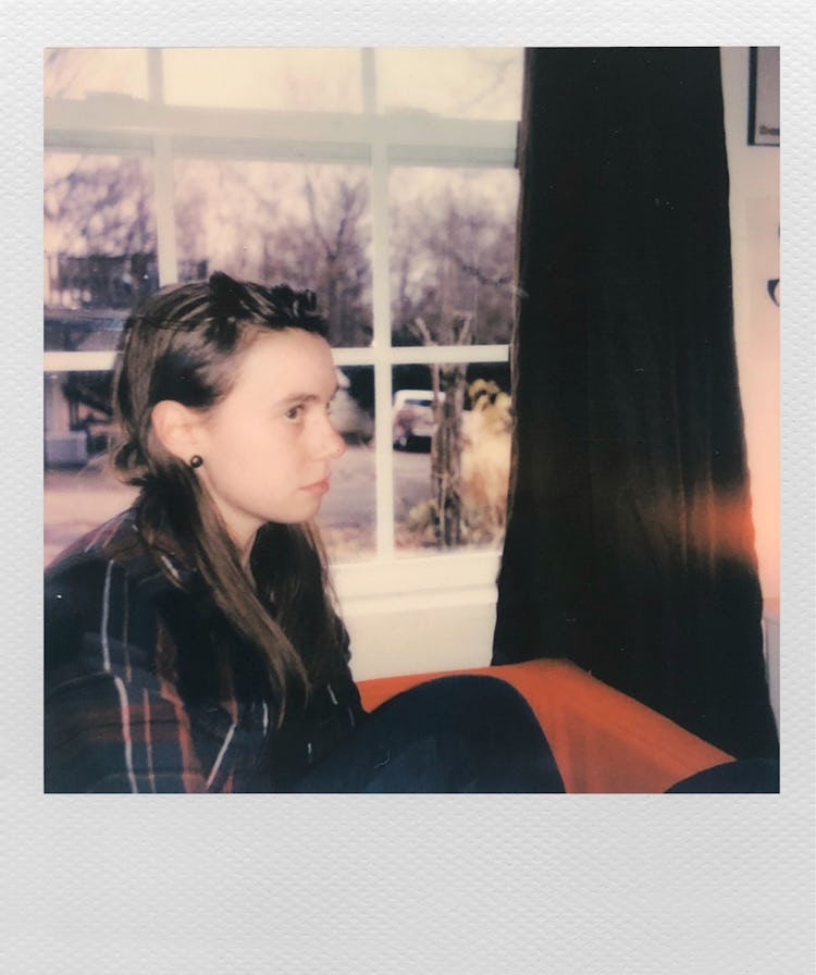 Polaroid of Julien Baker sitting by the window looking worried