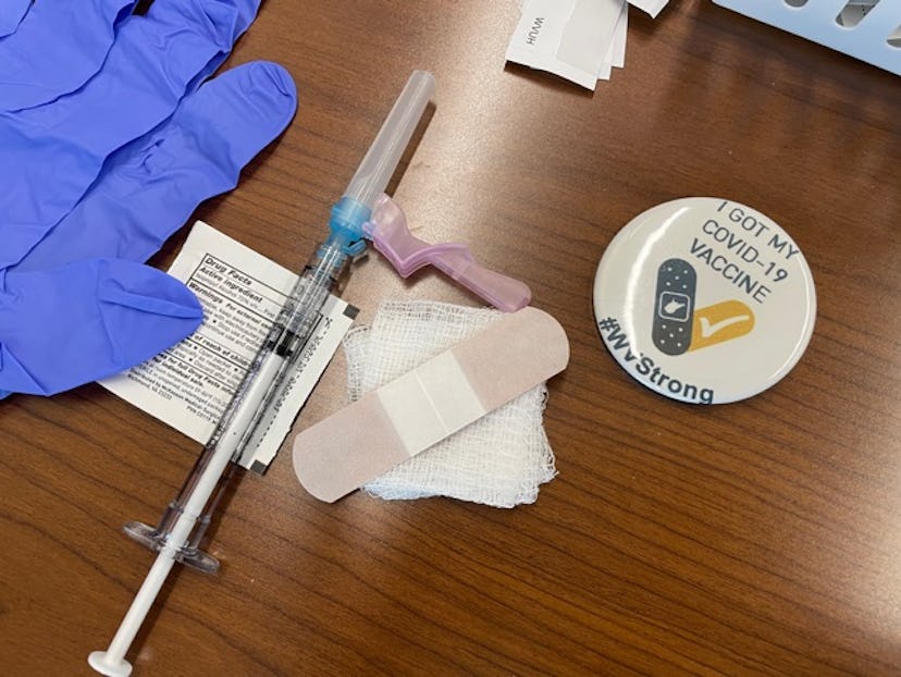 A COVID-19 vaccine, gloves, bandaid, and a COVID-19 vaccine sticker.