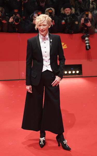 Tilda Swinton wearing a black suit with baggy pants and black heels