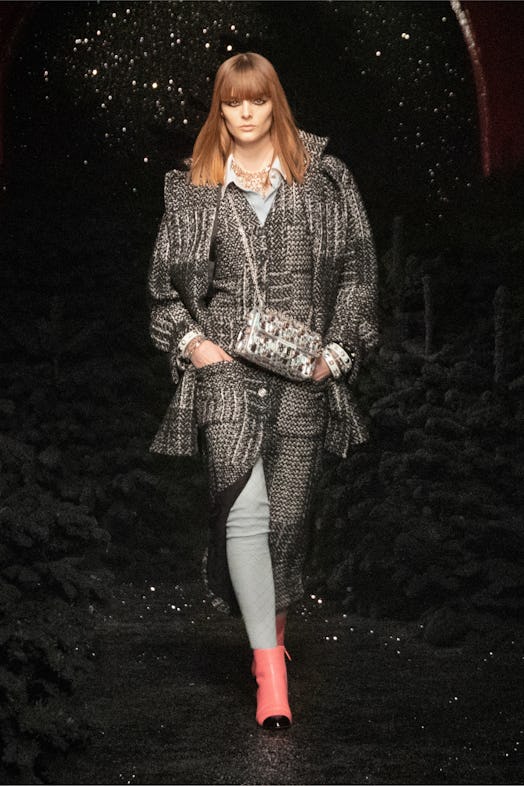 A female model walking in a grey coat