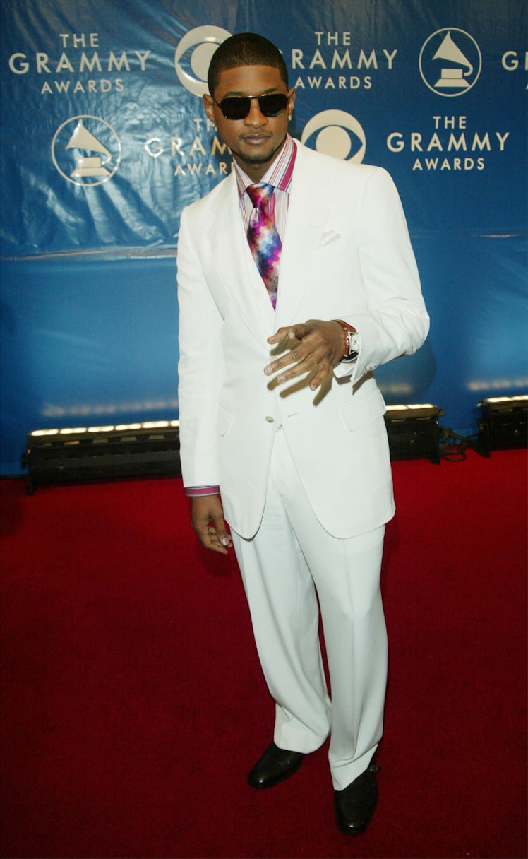 Usher posing on a red carpet in white suit