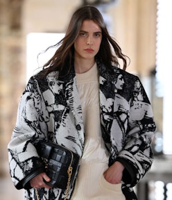 A female model wearing a black and white coat at the 2021 Paris Fashion Week