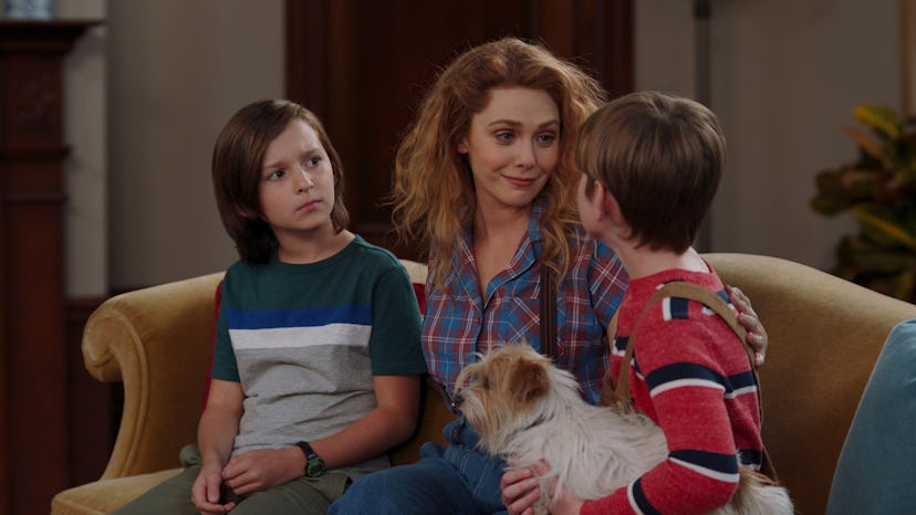 Wanda sits on the couch with her twin boys, who are 10 years old, with their new dog in WandaVision