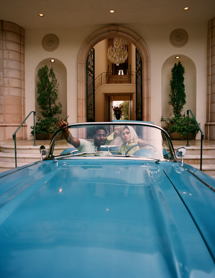 Zendaya and John David Washington sitting in a vintage blue car