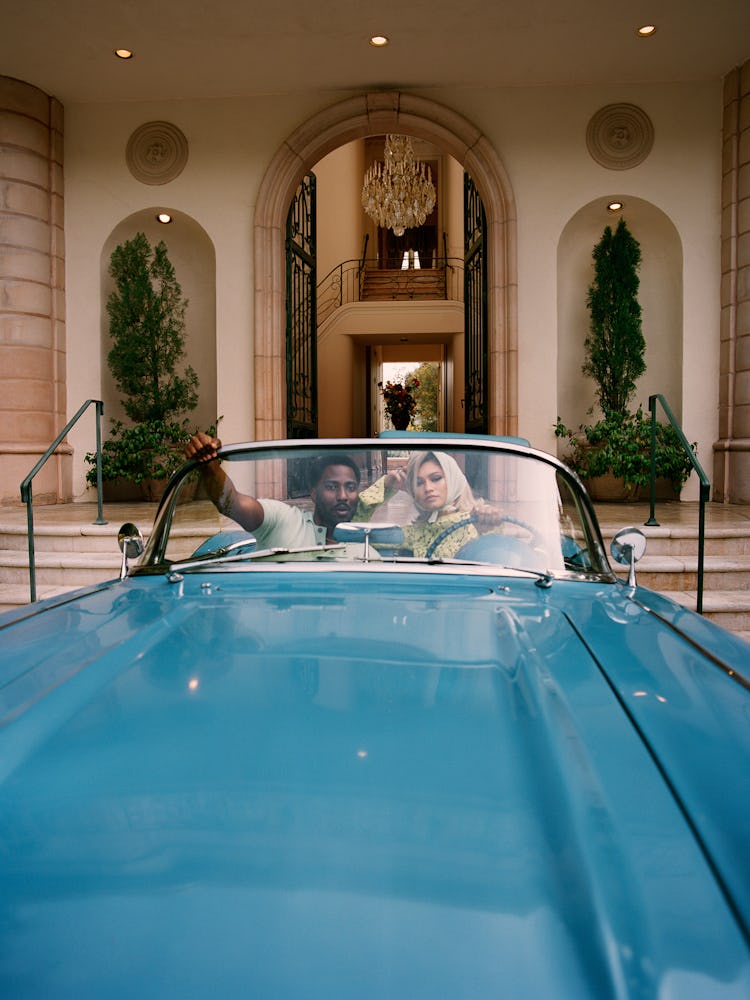 Zendaya and John David Washington sitting in a vintage blue car