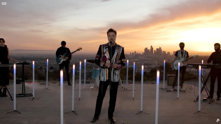 Rufus Wainwright on top of a building surrounded by a band performing at the 2021 Grammys