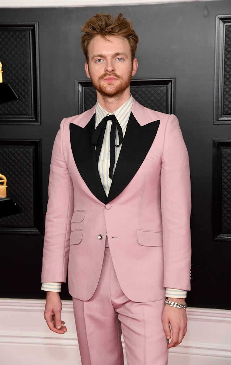 Finneas wearing a baby pink-colored suit at the 2021 Grammys