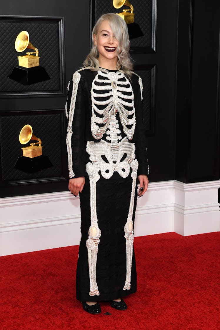 Phoebe Bridgers on the red carpet wearing a black Thom Browne dress with a skeleton pattern at the 2...