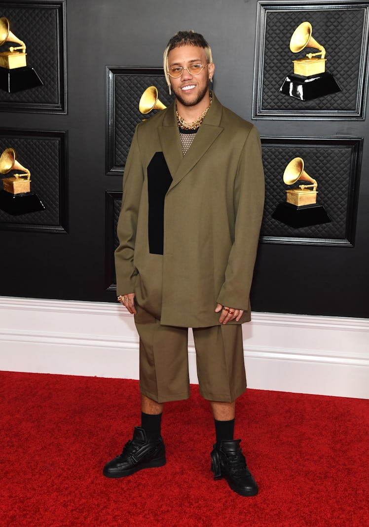 Jhay Cortez on the red carpet wearing a dark beige blazer and shorts at the 2021 Grammys