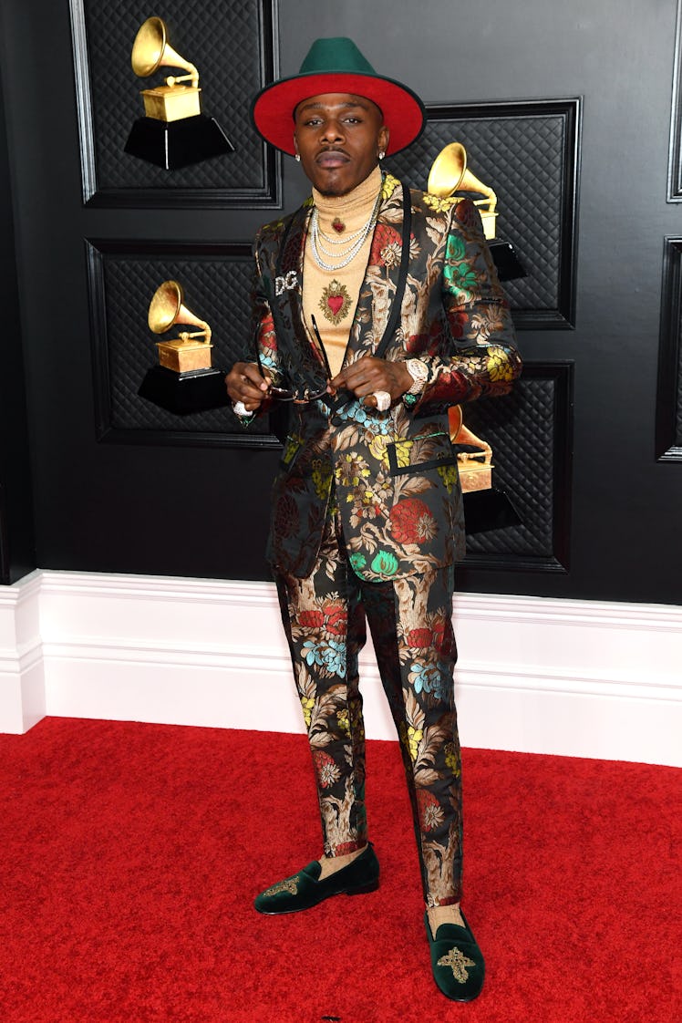 DaBaby on the red carpet wearing a black suit with a floral print and green suede hat at the 2021 Gr...