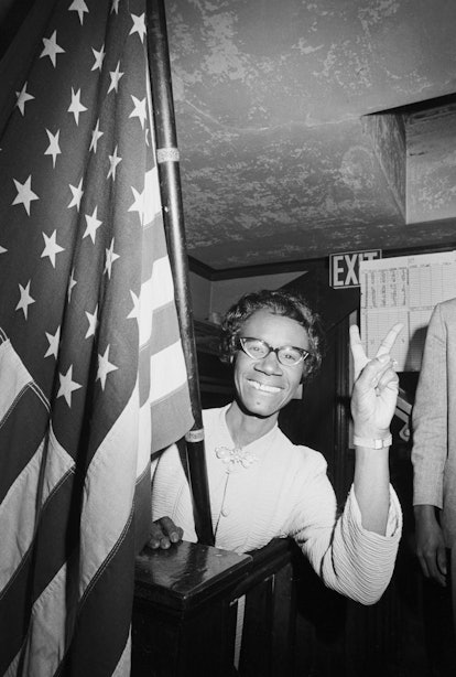 American politician Shirley Chisholm smiles and gives a victory sign after winning the Congressional...