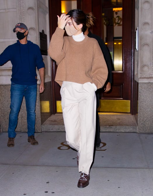 Kendall Jenner wears a brown sweater.