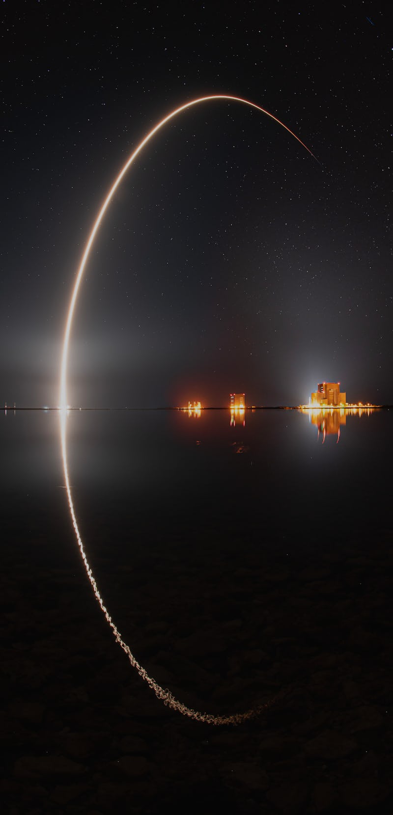 Falcon 9 rocket launch trail reflected in water