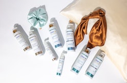 Dove's hair treatment products laid out with a silk scrunchy and headband from Brother Vellies