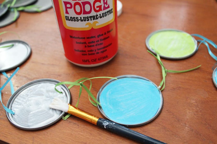 Use juice can lids to paint and make a garland.