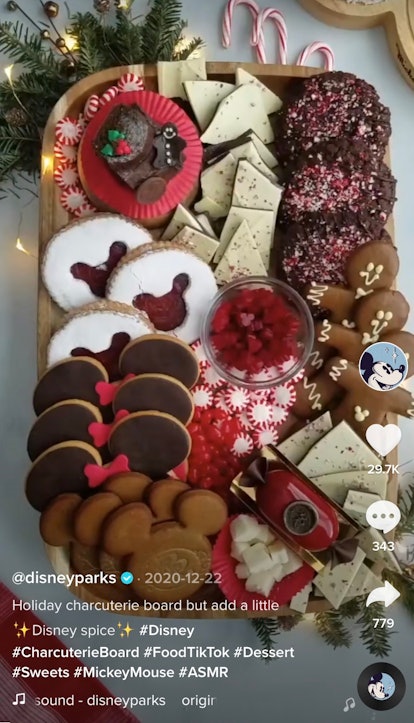 A Disney holiday-themed charcuterie board with cookies and peppermint sits on the kitchen counter. 