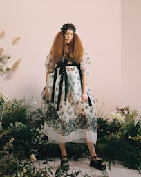A model in a white-black floral dress with a floral crown in Spring 2021