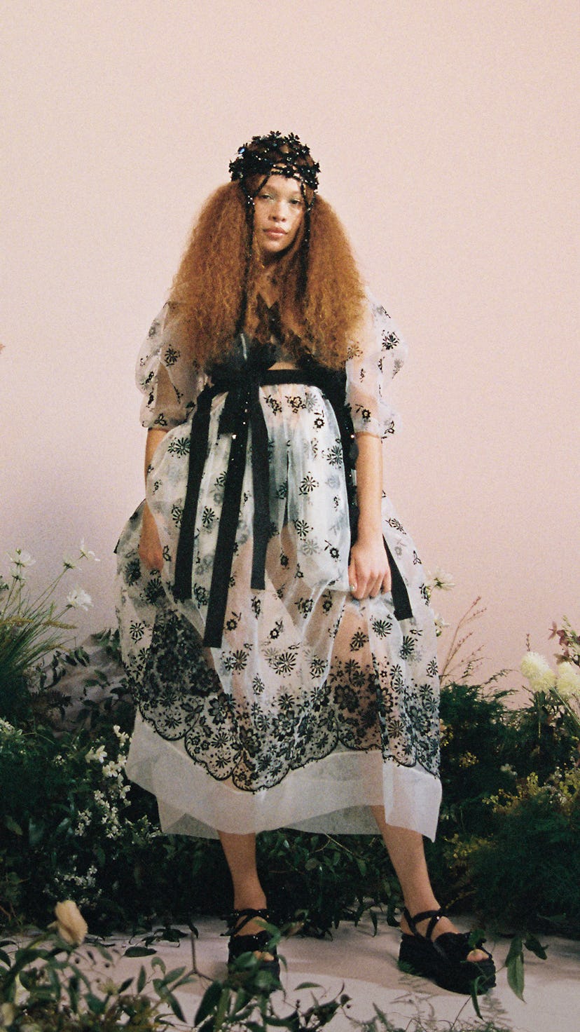 A model in a white-black floral dress with a floral crown in Spring 2021