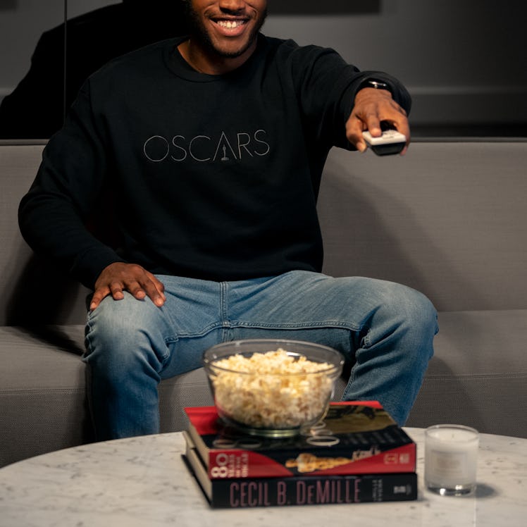 A person with popcorn using a remote