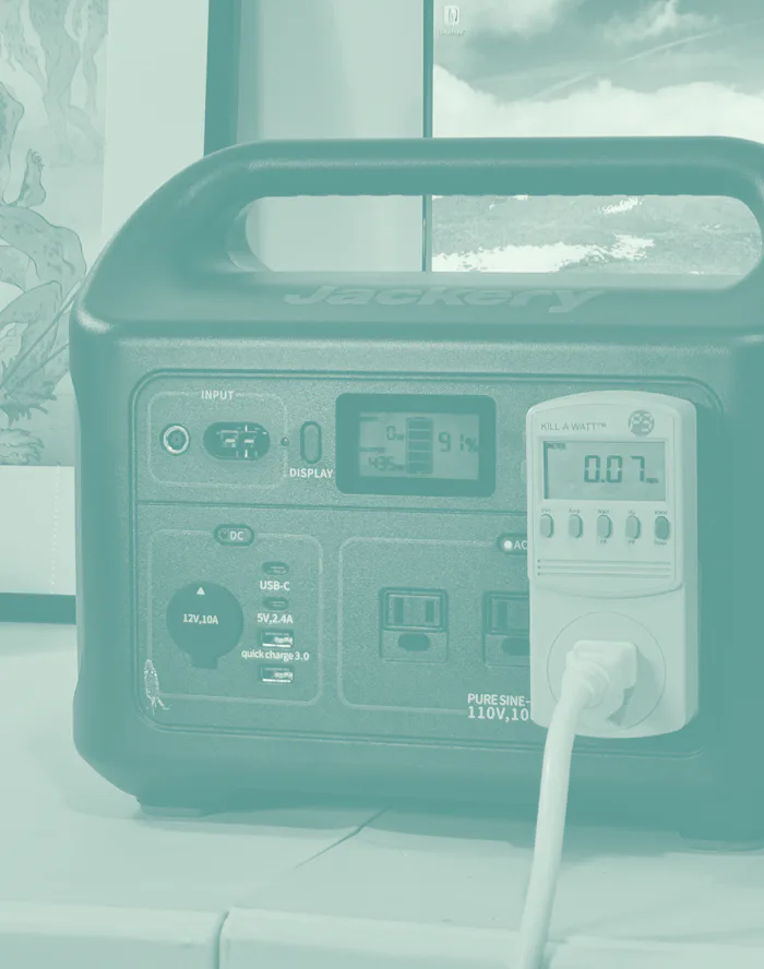 A shot of the Jackery Explorer 1,000 battery on a table with a cable plugged in.