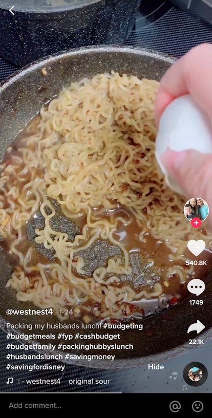 A TikToker adds an egg to a pan of ramen, while filming a viral ramen recipe.