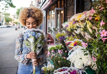 Young woman smelling flowers; flower captions for instagram, flower captions, flower caption