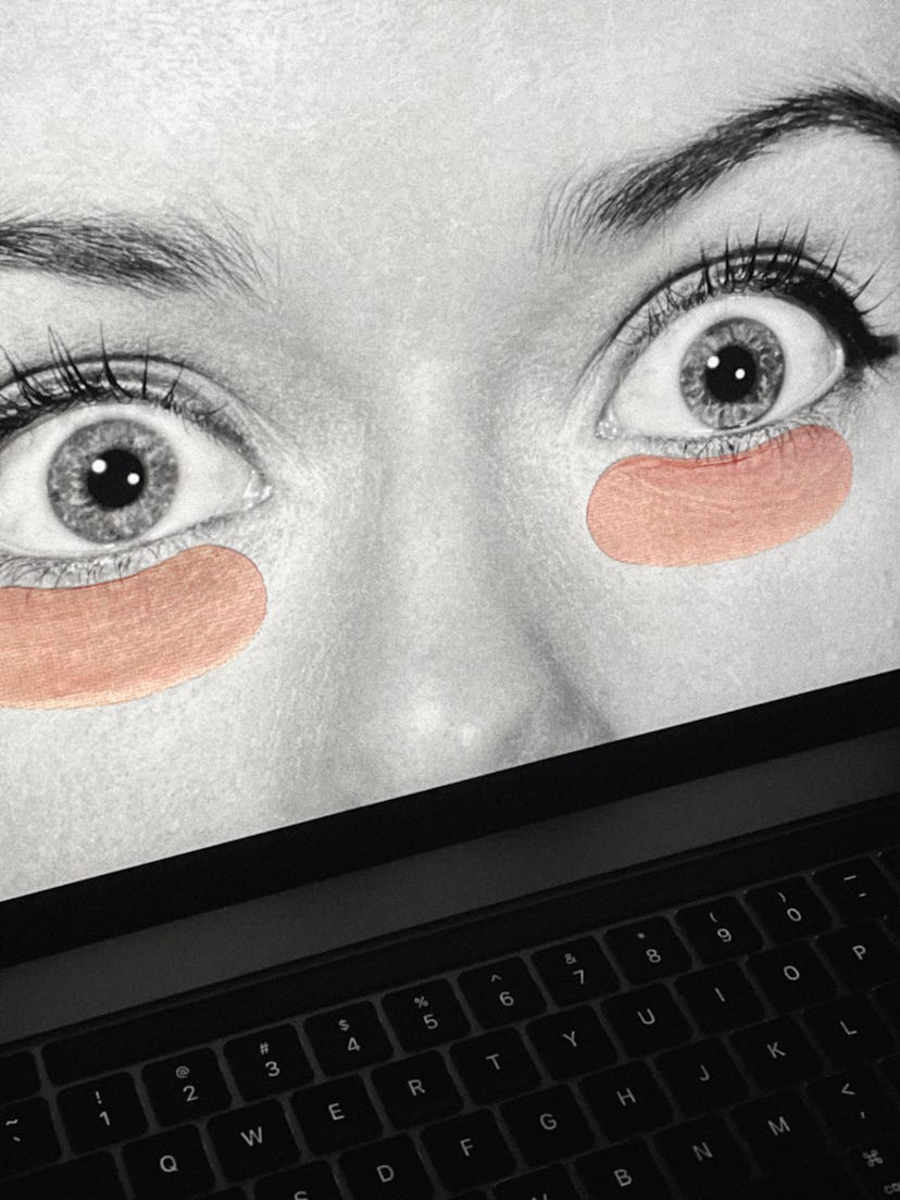A black-and-white image of a woman with eye mask patches on the screen of a laptop